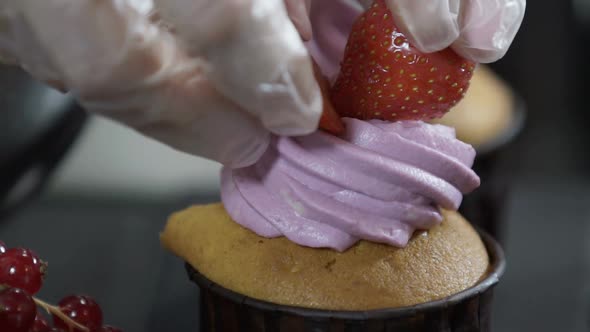 Decorating Cup Cake with Strawberry. Butter Cream on Tasty Muffins. Modern Desserts and Cakes