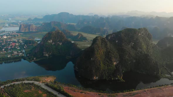 Aerial: North Vietnam karst landscape at sunset, drone view of Ninh Binh region, tourist destination