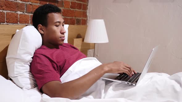 Angry Frustrated African Man Working Online at Night in Bed