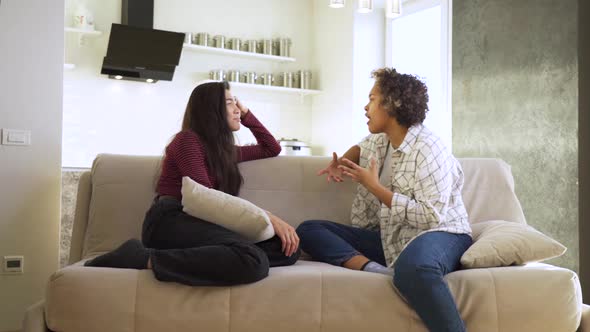 Slow Motion Two Girlfriends an AfricanAmerican and an Asian Chatting with Each Other While Sitting