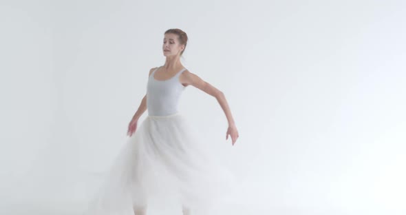 Elegant Female in a White Tutu Dance Ballet and Perform Choreographic Elements on a White Background