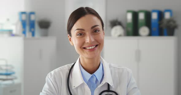 Portrait of Smiling Female Doctor Wearing White Coat with Stethoscope in Hospital Office