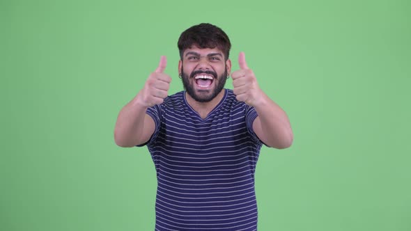 Happy Young Overweight Bearded Indian Man Giving Thumbs Up and Looking Excited