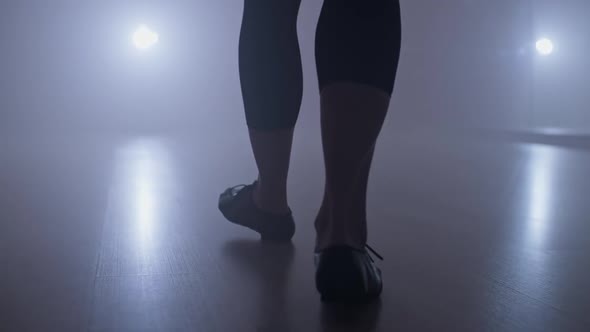 Silhouette of Dancer Legs Walking Through Dark Studio