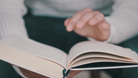 Young Man Reading a Book and Turning Pages Close Up Slow Motion