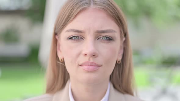 Close Up of Face of Serious Young Businesswoman Looking at Camera