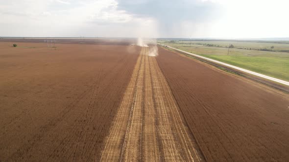 Aerial View of Harvester Machines Working in Wheat Field