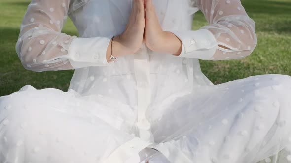 Woman Meditating Doing Yoga in the Park on a Sunny Day