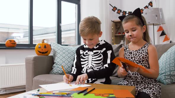 Kids in Halloween Costumes Doing Crafts at Home
