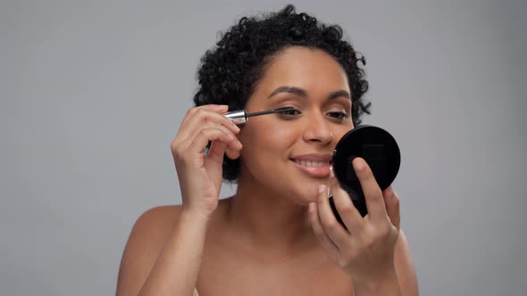 Beautiful African American Woman Applying Mascara