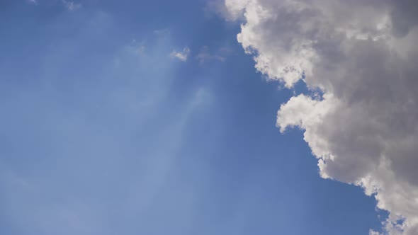 Timelapse of Clouds Formating in Layers with Blue Skies and Sun Rays in Behind