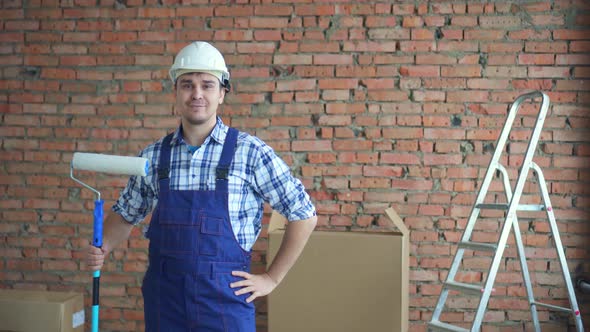 Man in a Working Uniform in a White Helmet After a Good Job