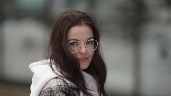 Portrait of a Beautiful Young Darkhaired Woman Without a Hat Wearing Round Glasses and a Plaid Coat