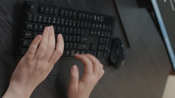 Vertical Video Closeup of Caucasian Programer Hands Typing Code on Keyboard in Front of Computer