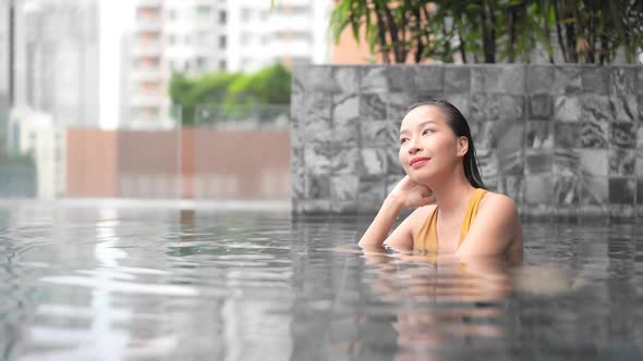 Young asian woman enjoy around outdoor swimming pool for leisure