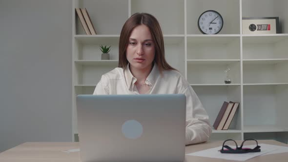 Confused Young Caucasian Woman Reading Email on Computer Feeling Depressed of Getting Bad News
