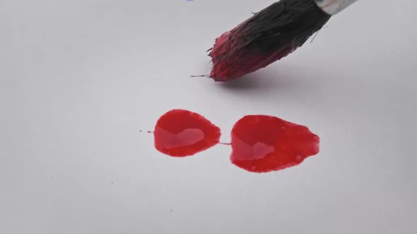 Brush With Red Paint Draws a Line on White Paper in Macro