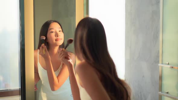 Young asian woman check her face on mirror