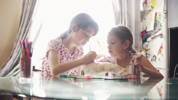 Children Draw Together on a Plastered Arm in a Bandage. Sister Encourages and Cares for a Sick