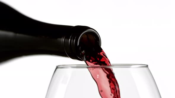 Super Slow Motion Detail Shot of Pouring Red Wine From Bottle on White Background at 1000Fps