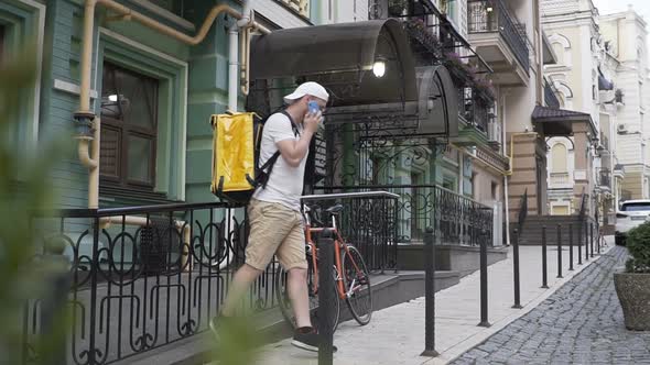 Delivery Man Courier Arrives at Residential Address To Deliver Food