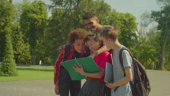 Group of Happy Diverse Multiethnic Students Reading Educational Material Outdoor