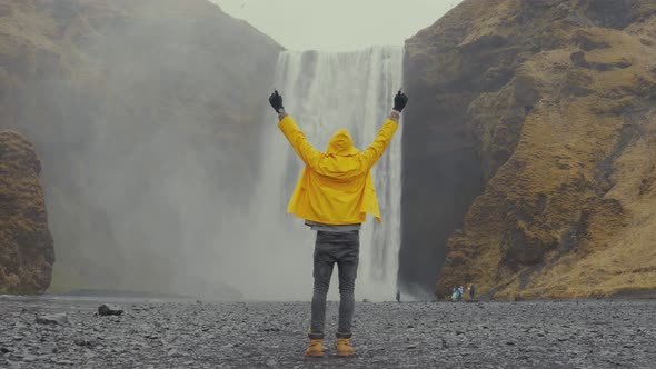 Man against cold waterfall