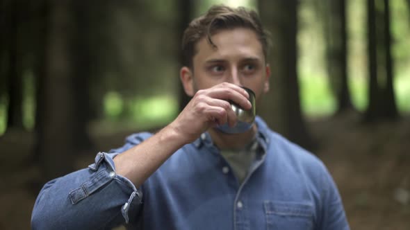 Hiker drinking coffee in the forest