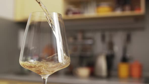 White wine is Poured into Transparent Glass