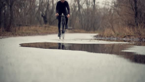 Cyclist Riding On Road Bike.Bike Wheels Rides Through Puddle. Cycling On Puddle And Splashing Water.