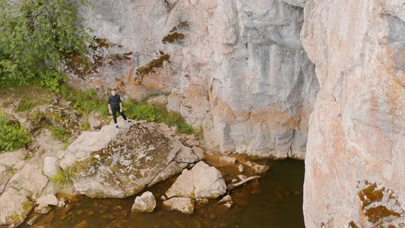 Traveler is standing on the top rock of the water gorge Rocks by the river