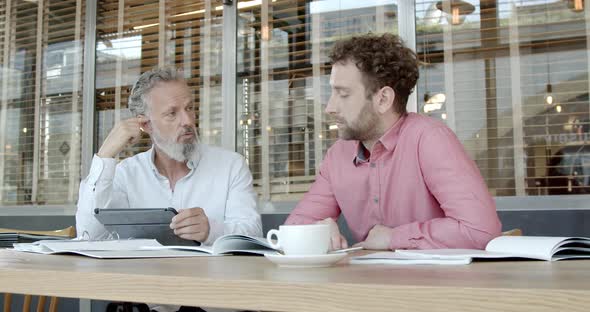 Two business partners having a meeting at a cafe