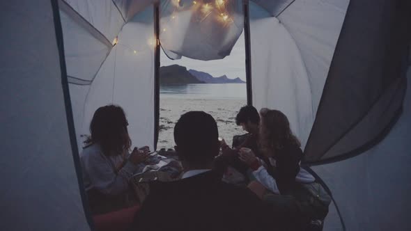 Group of travelers in camping tent on shore