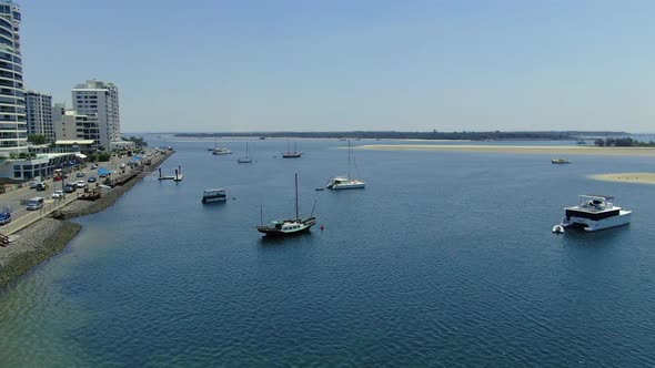 Drone flying north at Labrador , waterside suburb , flying among sail boast and cruisers