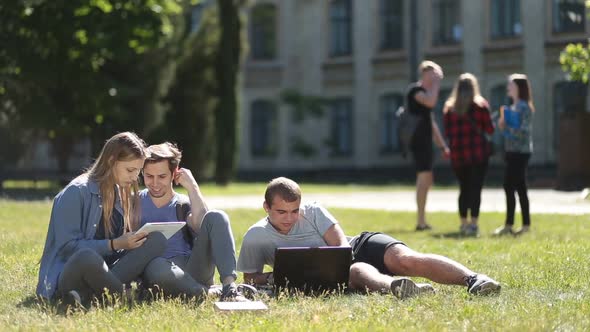 College Students Using Laptop and Tablet on Lawn