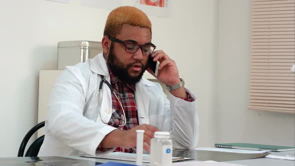 African American Male Medical Worker Answering Phone Call at His Desk