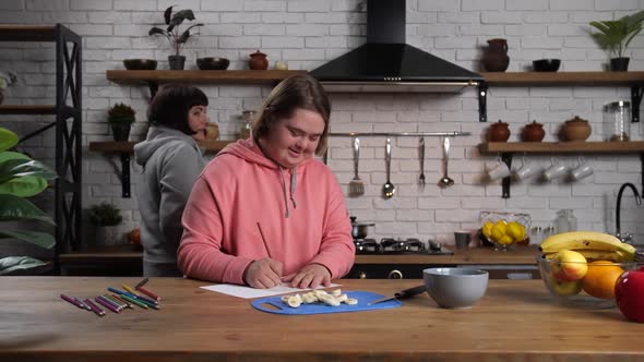 Positive Handicapped Girl Drawing at Kitchen Table