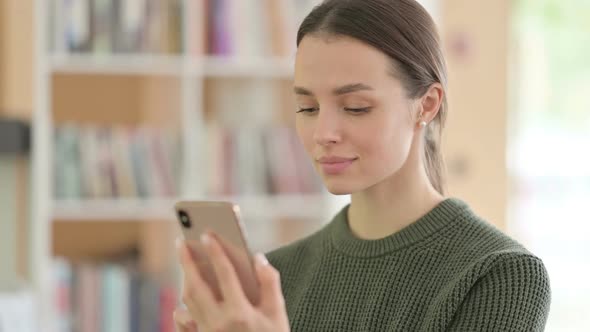 Portrait of Young Woman Using Smartphone Browsing Internet