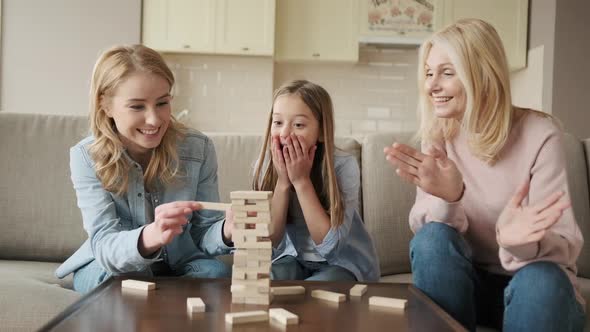 Happy Family Playing Funny Board Game Enjoying Leisure Time Sitting on Cozy Couch at Home Smiling