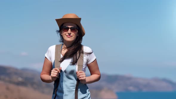 Beautiful Active Hiker Backpack Woman Walking on Top of Mountain at Sea and Sky Background