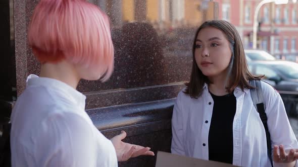 Two Females Students in White Shirts Talking