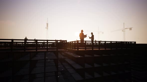 Construction Engineers In The Discussion Schemes With Workers And Silhouette alt