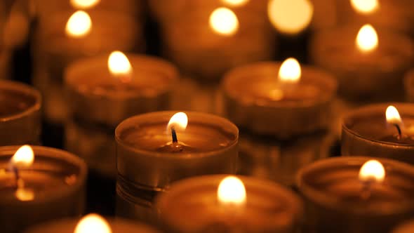 Many Small Burning Candles on a Black Background alt