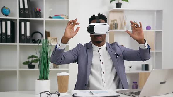 Smart Dark-Skinned Office Manager Working in Virtual Reality Headset in Office