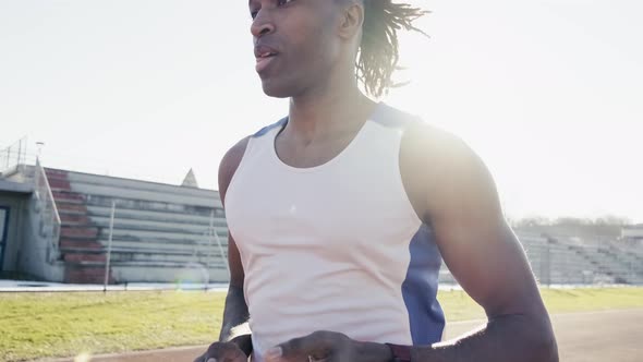 Male athlete run on running track in a stadium