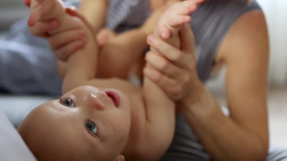 Loving Mother Hands Playing with Infant Baby Arms and Feet Legs Happy Family