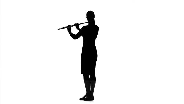 Musician Girl Playing on Flute in Slow Motion. White Studio
