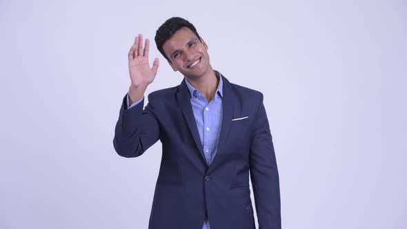 Young Happy Indian Businessman in Suit Waving Hand