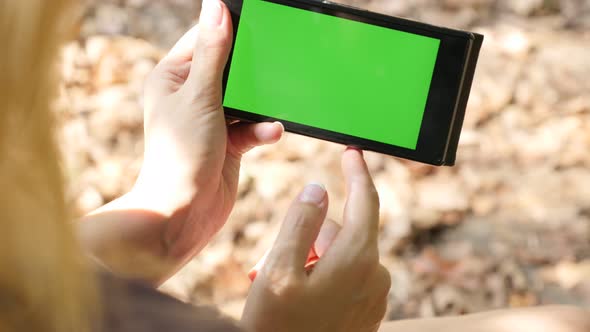 Smart phone with green screen display  in nature close-up 4K 2160p UltraHD footage - Woman holding i