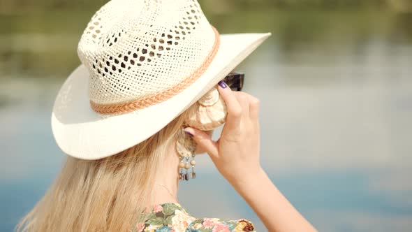 Dreaming Woman Relaxing Trip On Summer Days. Woman Holding Sea Shell In Hand And Listening Noise.